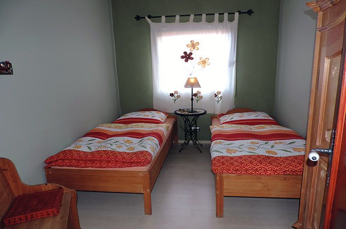 Einfach eingerichtetes Zweibettzimmer in der Villa Faisan Teneriffa mit Massivholzbetten