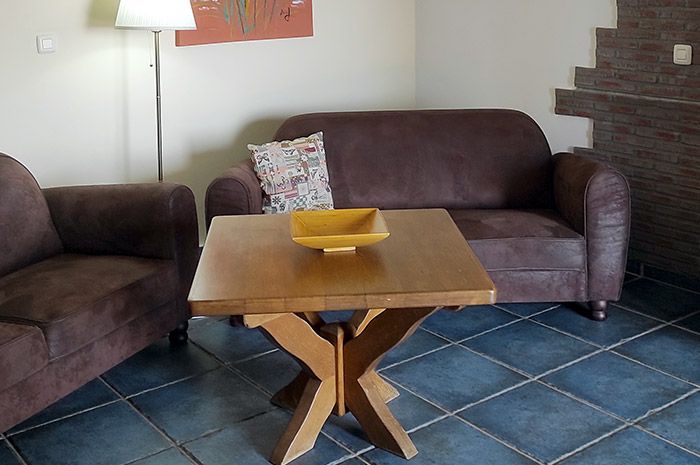 Wohnbereich mit Sofa und Holztisch in der Ferienwohnung Turmwohnung Teneriffa