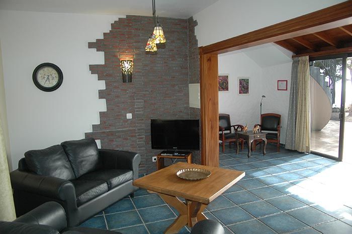 Wohnzimmer mit Kamin, Holzbalken und Sitzgruppe in der Ferienwohnung Turmwohnung Teneriffa