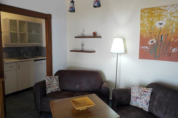 Wohnzimmer mit Sofa, Küche und Essbereich in der Ferienwohnung Turmwohnung Teneriffa